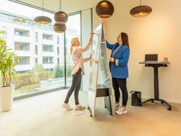 Zwei Frauen arbeiten parallel an Whiteboard