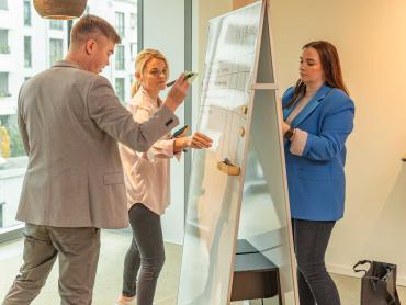 Kollegen arbeiten gemeinsam an Whiteboard