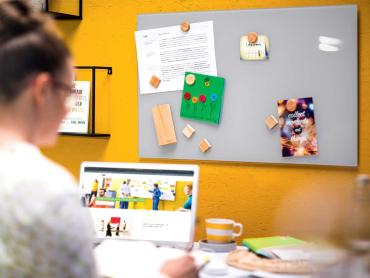 Frau sitzt an Schreibtisch im Homeoffice und arbeitet