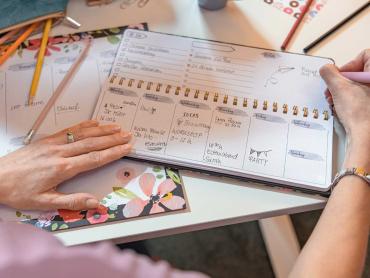 Frau schreibt Notizen in Tischplaner