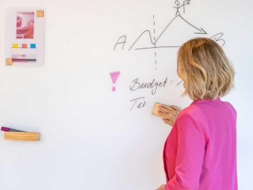 Mitarbeiterin arbeitet an Whiteboard