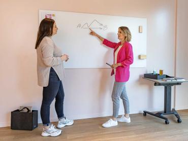 Zwei Kolleginnen visualisieren gemeinsam am Whiteboard