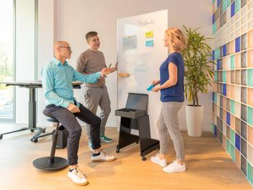 Team erarbeitet Optimierung von Prozessen an Whiteboard