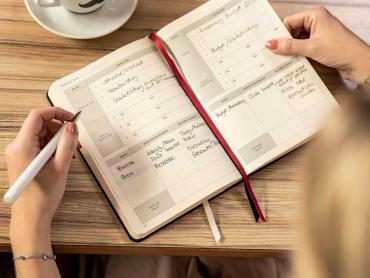 Frau schreibt in undatierten Kalender
