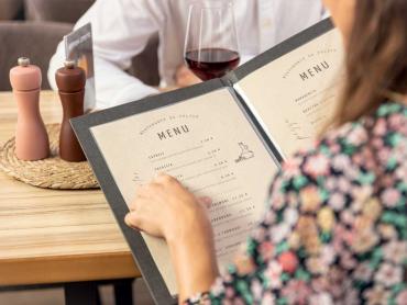 Frau zeigt in Speisekarte auf ein Gericht