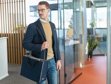 Mann trägt Desk Sharing Bag Bicolor in dunkelblau/beige