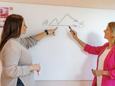 Kollegen analysieren Projektverlauf an Whiteboard
