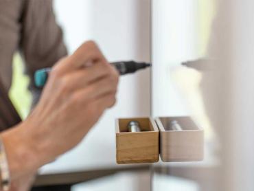 Hand schreibt mit Boardmarker auf Whiteboard