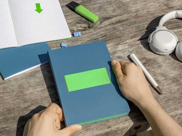Linescape Neo Notizbuch in blau, neben Kopfhörer, Kugelschreiber und Farbstift