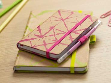 Jolie Buchkalender in gelb und pink liegen aufeinander auf Schreibtisch