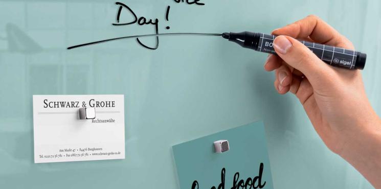 Mensch beschriftet Glas-Whiteboard