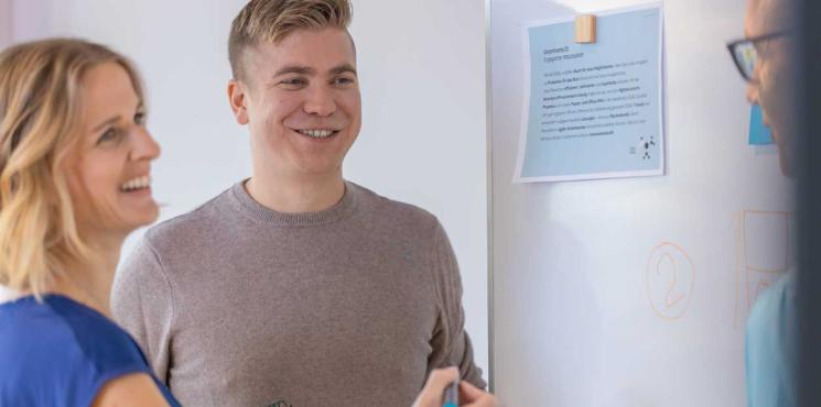 Kollegen arbeiten an Whiteboard zusammen