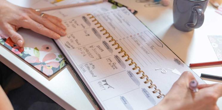 Frau notiert Termine in Jolie Tischkalender