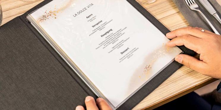 Mann liest in offener Speisekarte