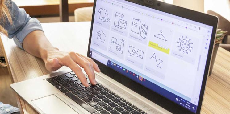 Frau tippt auf Laptop mit Smartpro Print-on-demand-Shop