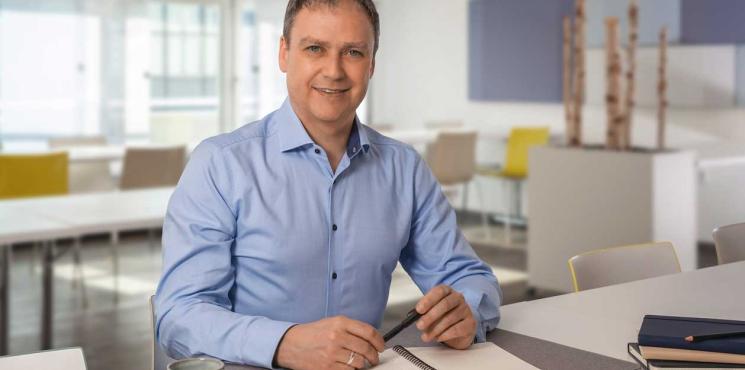 Daniel Petrasch sitzt an Tisch mit einem Notizbuch