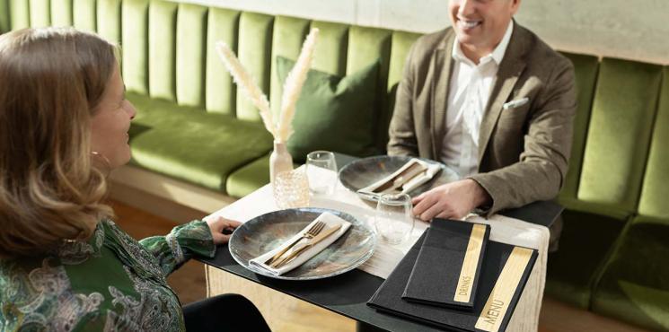 Ein Paar sitzt in einem Restaurant am gedeckten Tisch. 