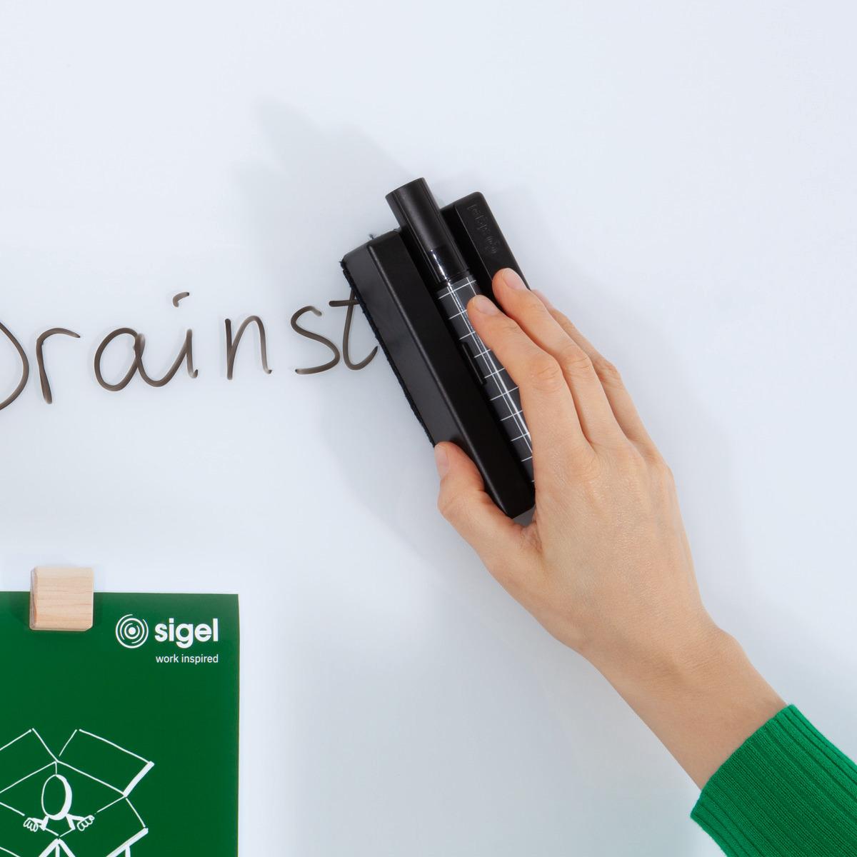 Hand wipes writing from blackboard Green clipboard underneath