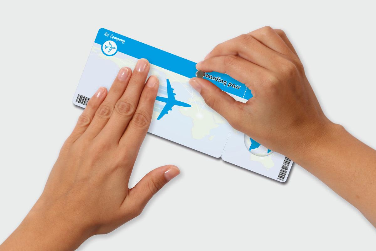 Hands holding and scratching a scratch field on a plane ticket