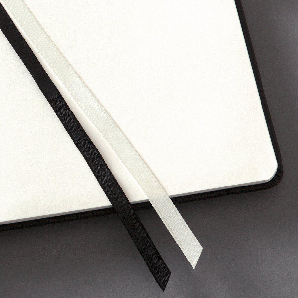 Offenes Notizbuch mit schwarzem und weißem Lesezeichen