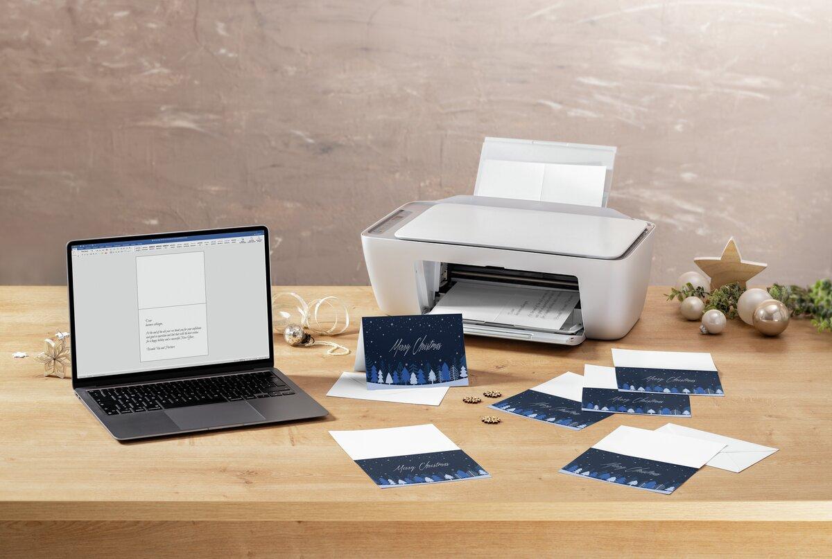 Laptop and printer on wooden table, Christmas cards