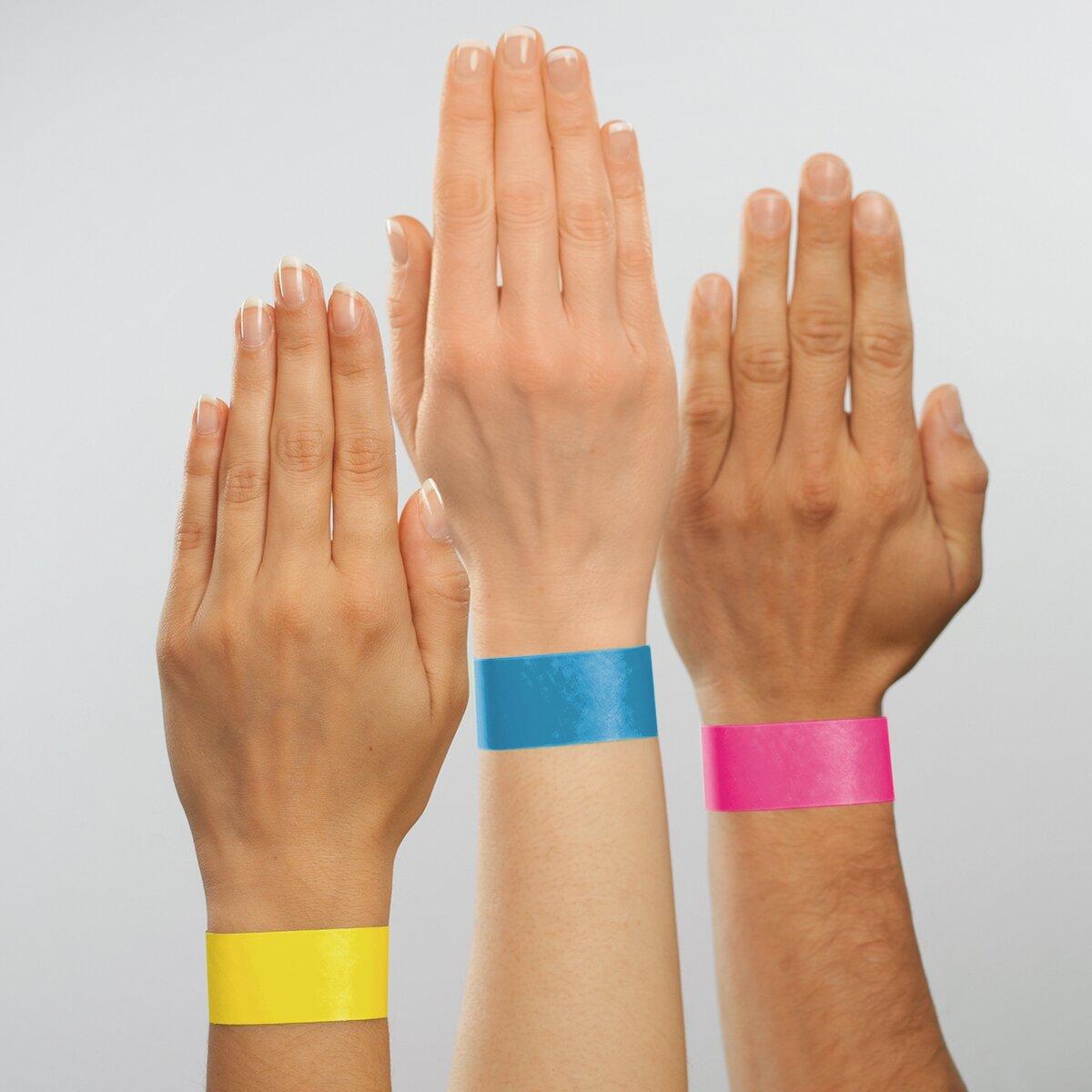 Three hands held up, bracelets in yellow, blue and pink