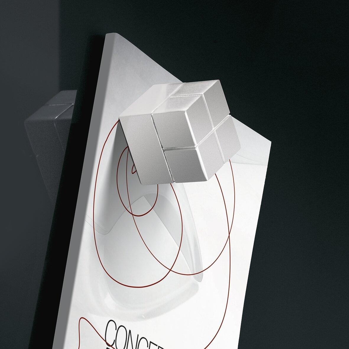 Silberner Würfel auf weißer, grafisch gestalteter Fläche mit roten Linien