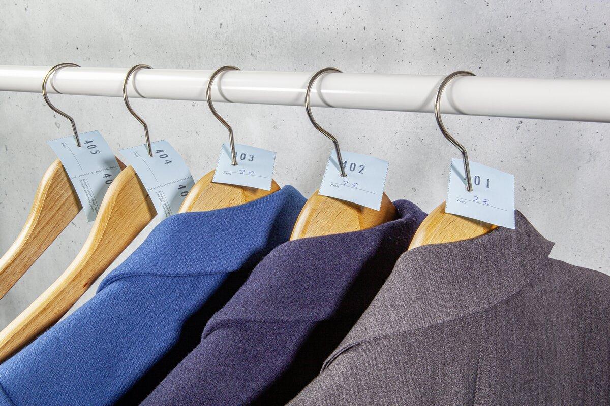 Holzbügel mit Jacken und Etiketten