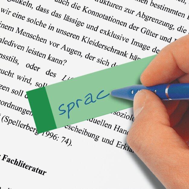 Grüner Notizzettel auf Textseite, Hand schreibt