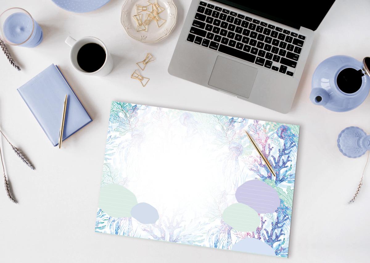 Laptop auf Schreibtisch mit Notizbuch, Tasse Kaffee, und bemaltem Papier