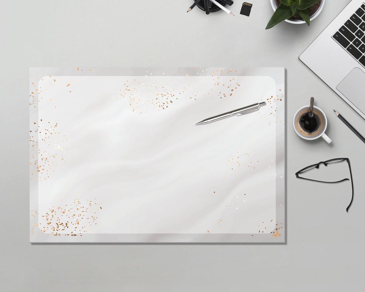 Schreibtisch mit Laptop, Kaffeetasse, Brille und Notizbuch