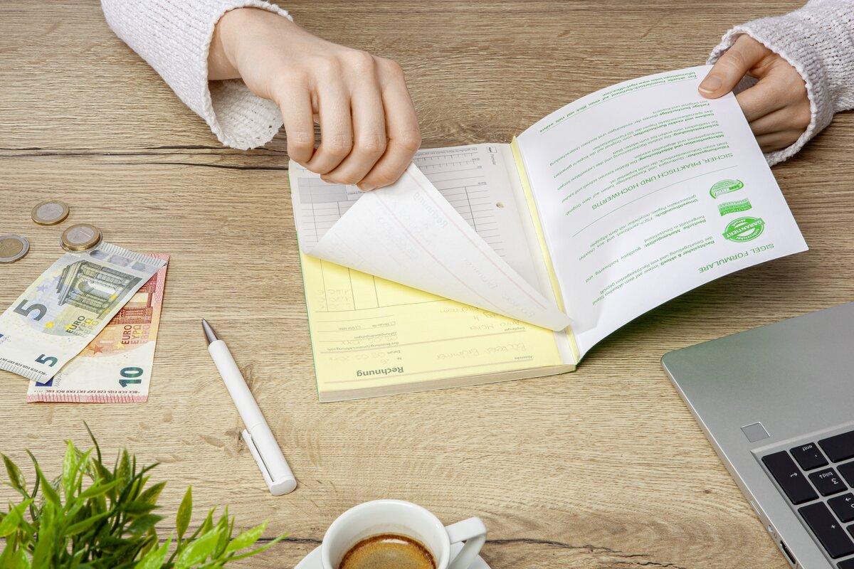 Hand blättert Papier, Euros, Laptop