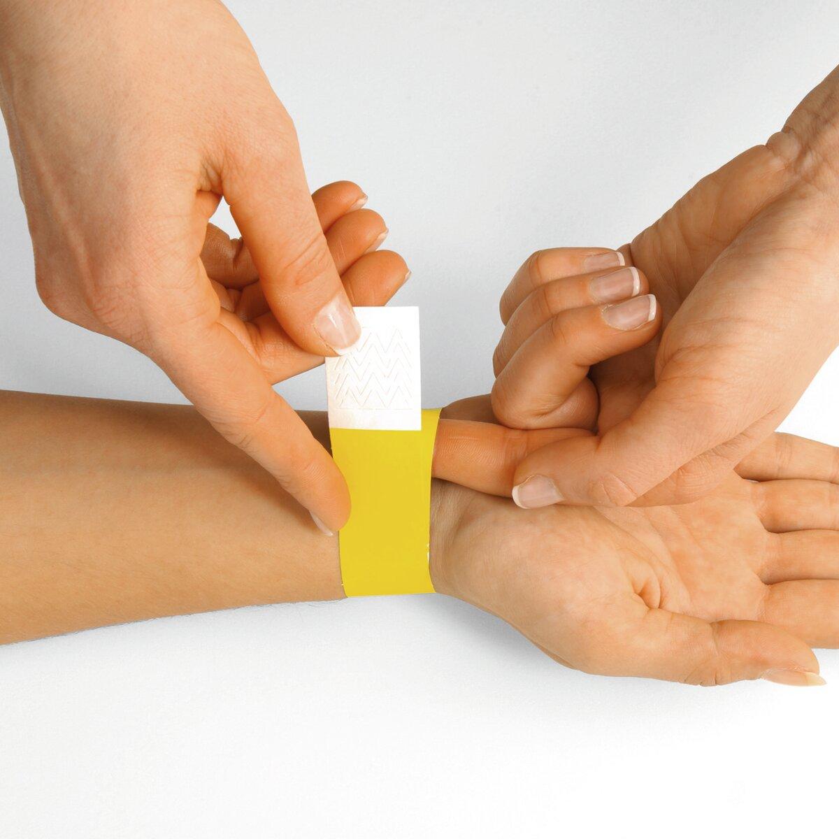 Yellow bracelet is attached to the wrist, hands help