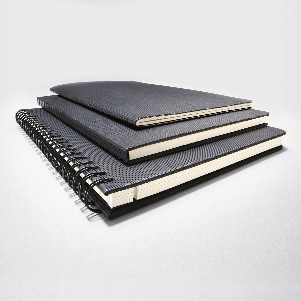 Drei schwarze Notizbücher, übereinander gestapelt