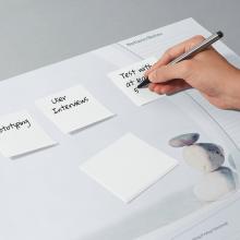 Hand schreibt auf Notizzettel