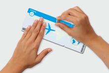 Holding hands and scratching Scratch card in the shape of a plane ticket