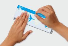 Hands holding and scratching a scratch field on a plane ticket