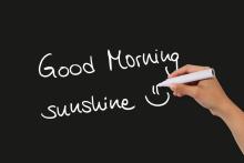 "Good Morning Sunshine" is written in white on a black background with a pen