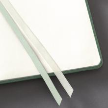 Offenes Notizbuch mit grünem Rand Zwei Lesebänder liegen darauf