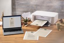 Laptop and printer on wooden desk, printing documents