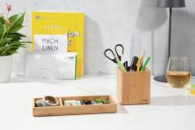 Schreibtisch mit Schreibutensilien Pflanzen und Getränkeglas