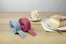 Zwei Rollen mit Wertmarken, eine Tasse und ein Stück Kuchen