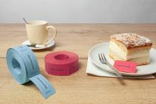 Kaffeetasse, zwei Wertmarkenrollen, Kuchenstück auf Teller mit Gabel