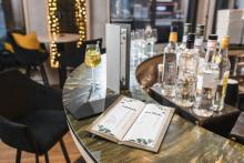 Getränkekarte auf einer Theke Cocktailglas und Flaschen im Hintergrund