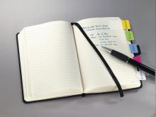 Notizbuch mit Taben und Stift