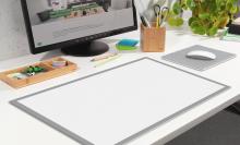 Schreibtisch mit Monitor, Schreibutensilien und Pflanze