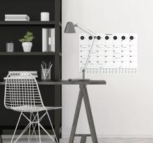 Schreibtisch mit Lampe, Kalender an der Wand