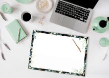 Laptop, Notizblock und Tasse auf Schreibtisch