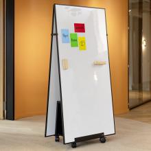 Whiteboard on wheels with colorful notes, in front of orange wall