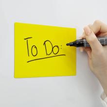 Yellow note with To Do on it; Hand holding black pen